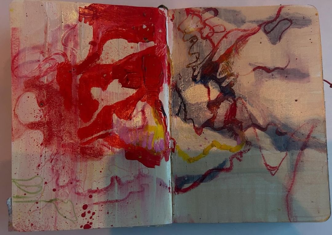 Sketchbook spread of gestural red brushwork and a fine wandering line over a pale gold-washed ground.
